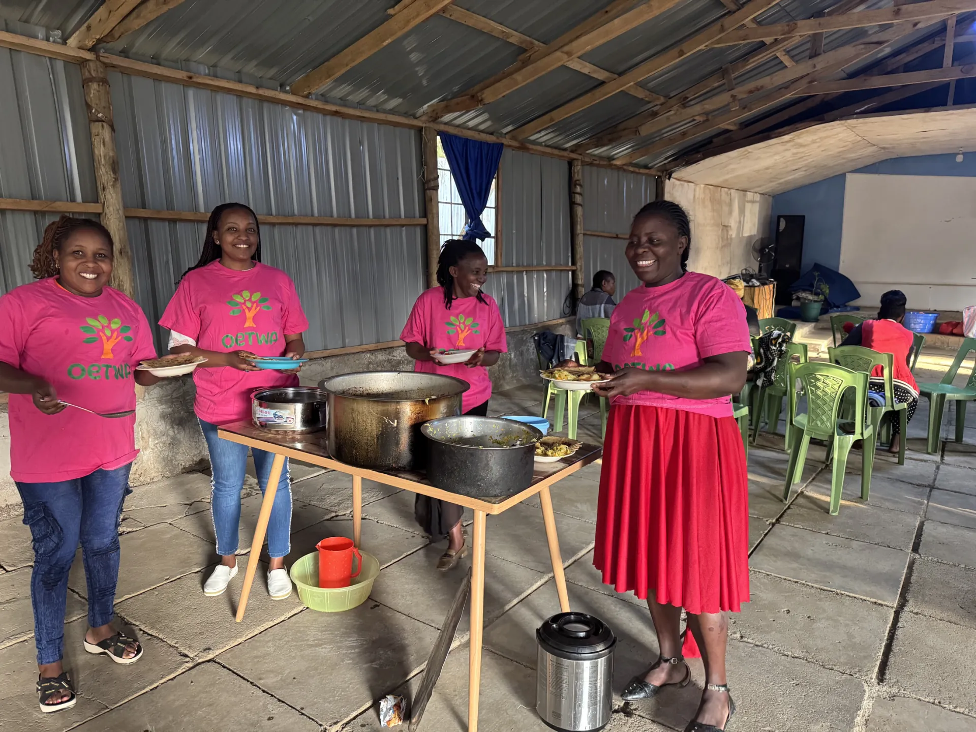 OETWA volunteers smiling during a community meal