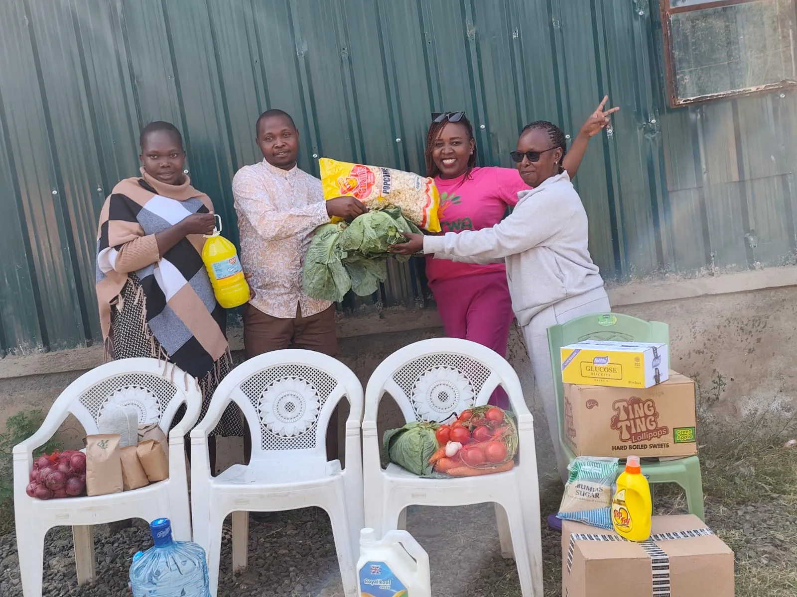 OETWA team and community members presenting food and household supplies for local support