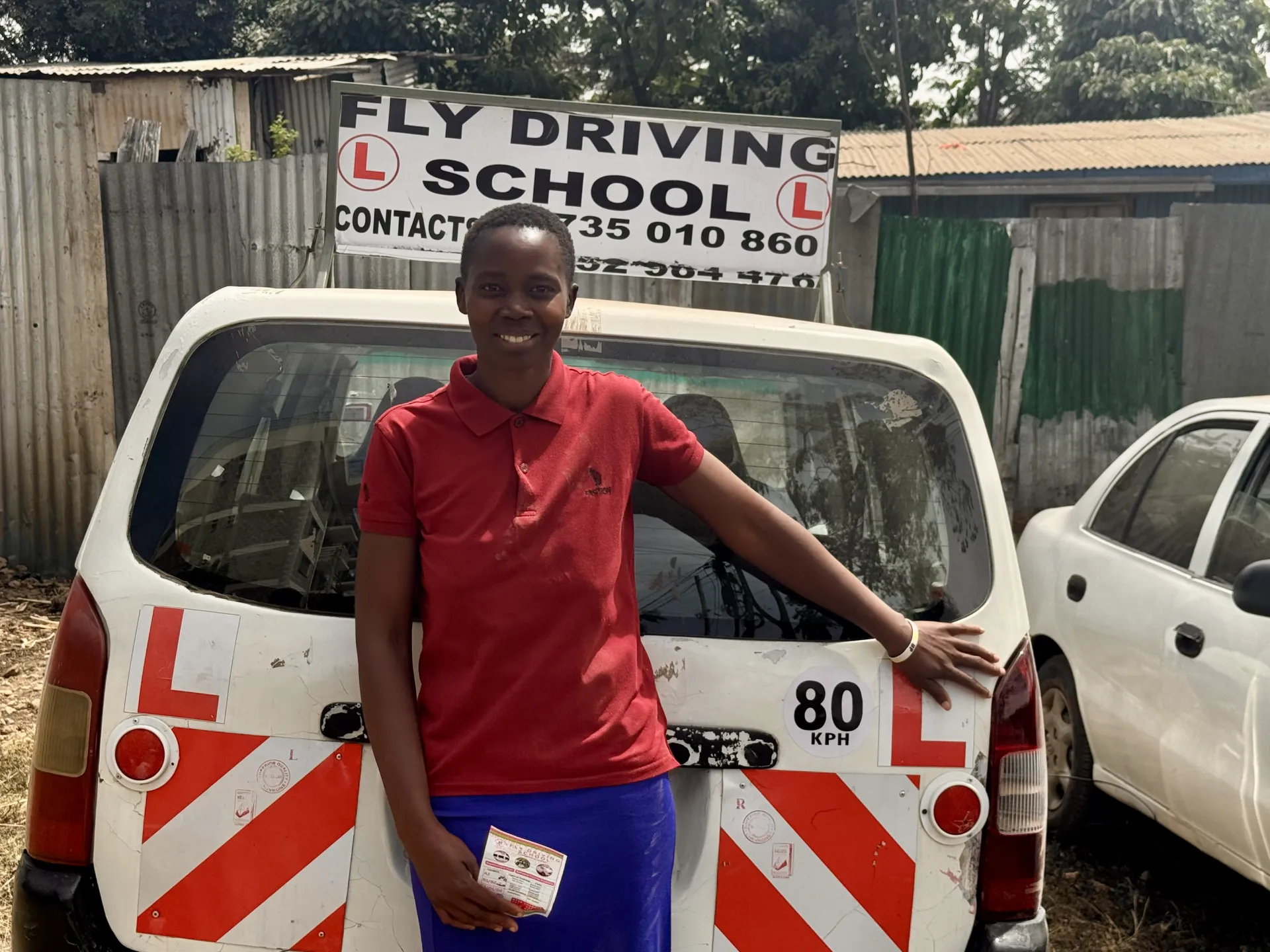 A driving programme participant proudly holding her new driving credentials