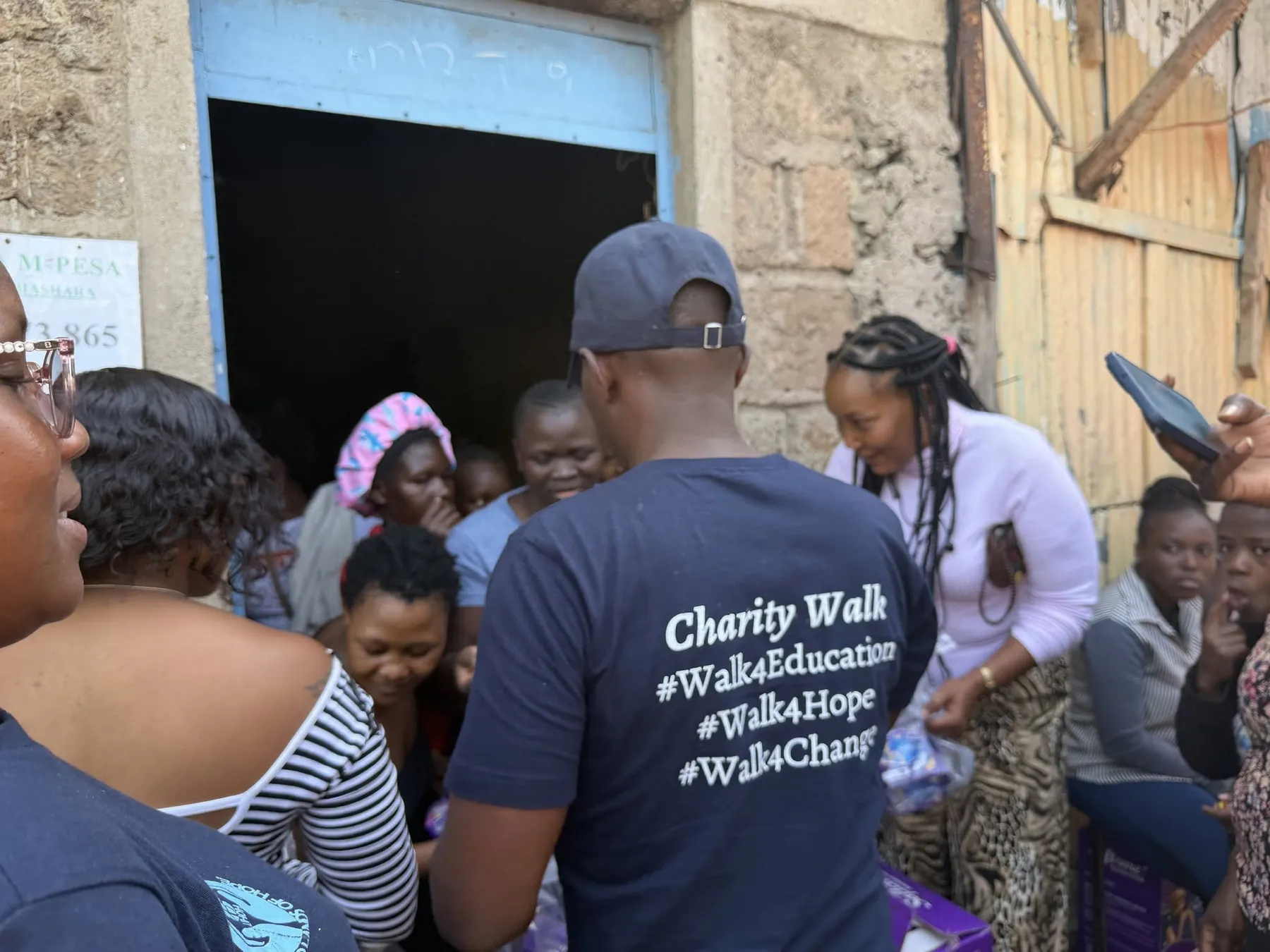 OETWA volunteers and community members gathering during a menstrual-care supply visit