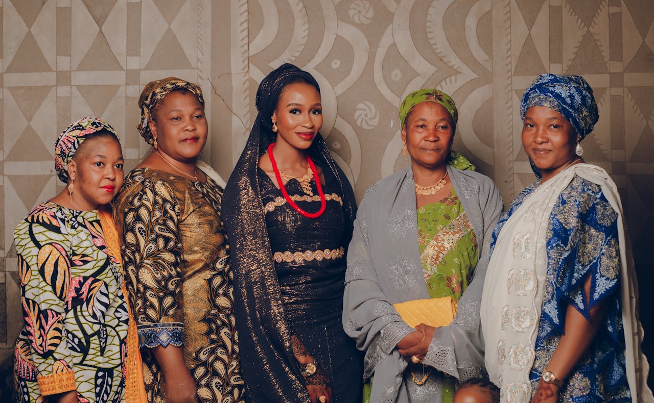 Group of African women wearing colorful traditional outfits in a cultural event.